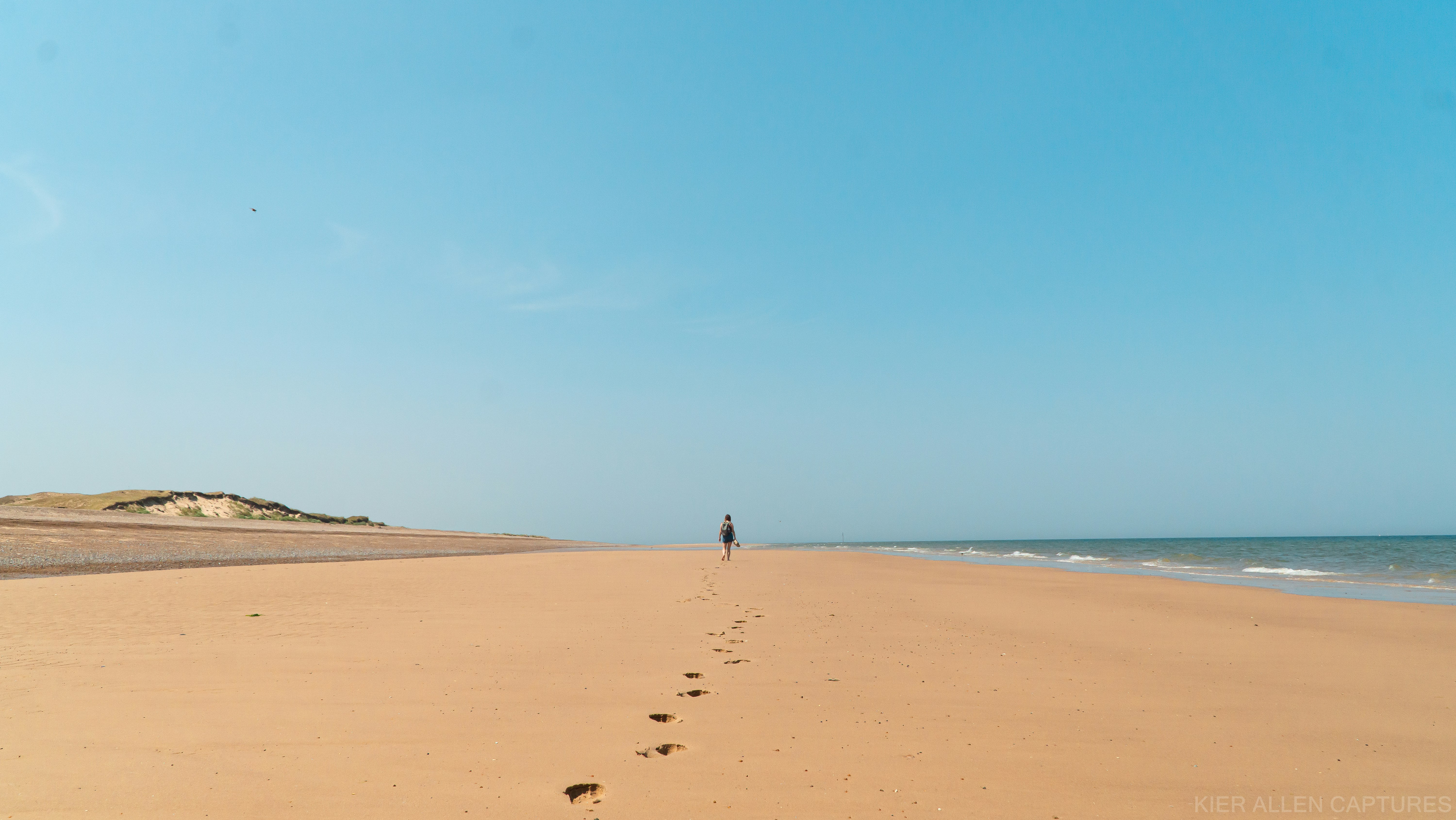 person walking on beach during daytime